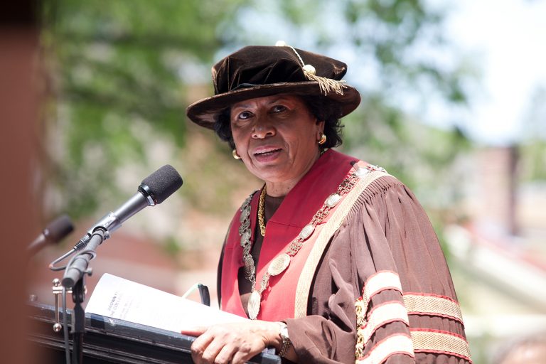 A portrait of Ruth J. Simmons delivering commencement at a podium.